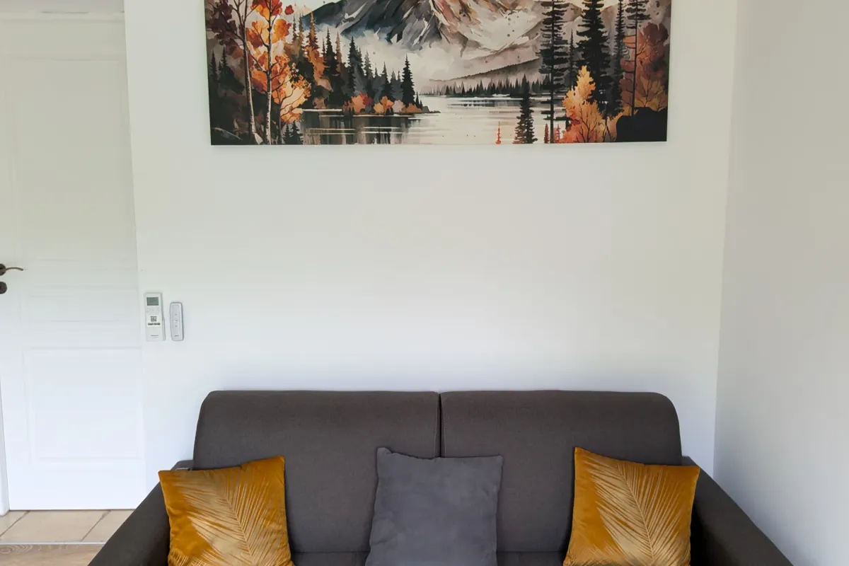 Le coin salon du studio, avec canapé-lit et climatisation — L'Escale du Midi, Renneville