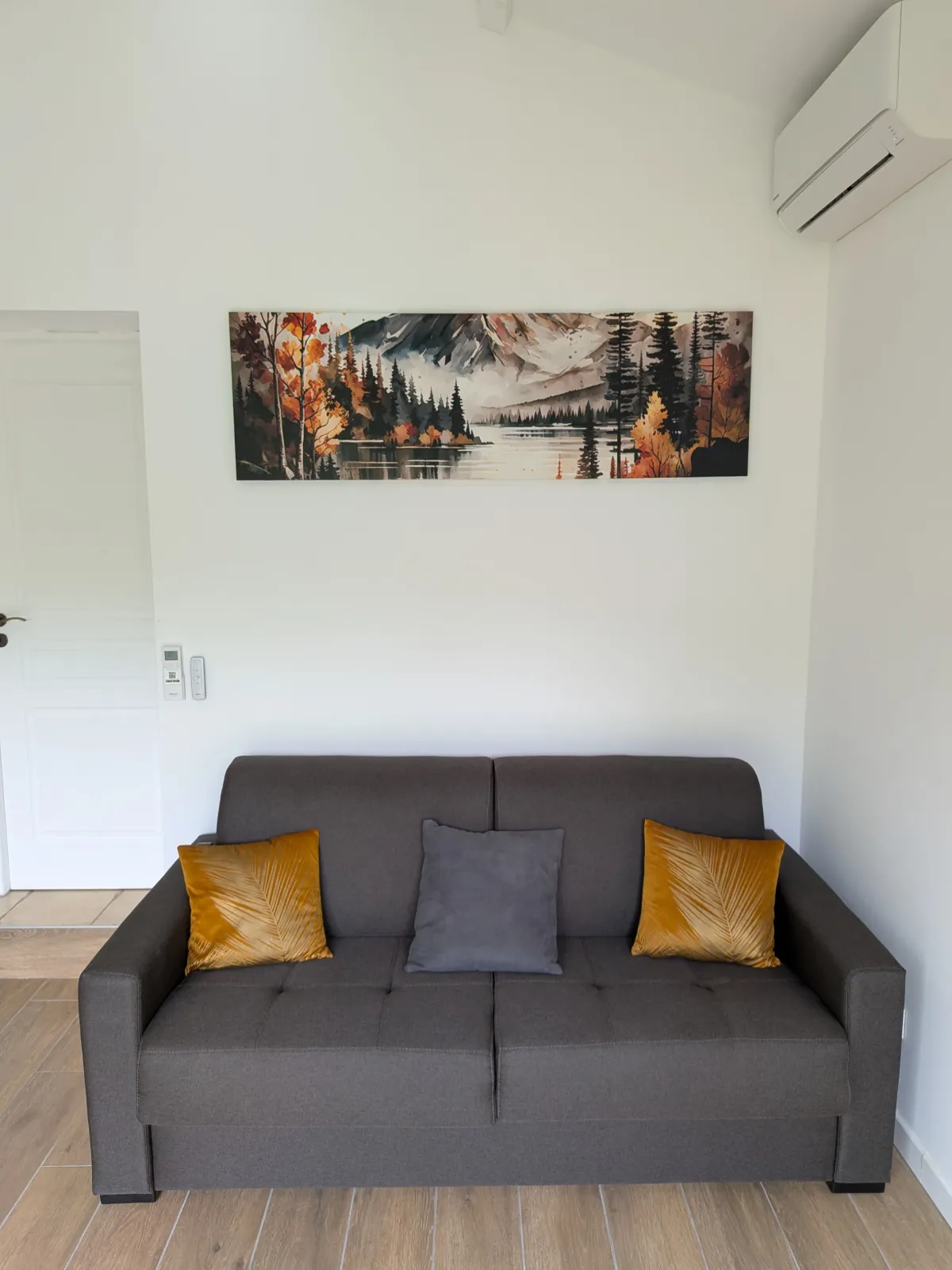 Le coin salon du studio, avec canapé-lit et climatisation — L'Escale du Midi, Renneville